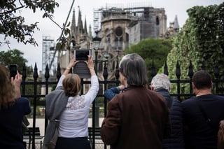 Turistas caminan junto a la catedral de Notre Dame de París tras la creación de una zona de seguridad para los visitantes. (EFE)
