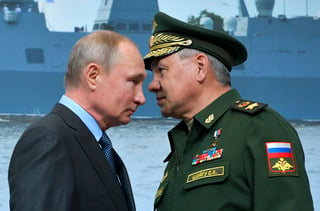 Vladimir Putin (Izq.) y su ministro de Defensa, Sergei Shoigu, conversan durante una visita a un astillero en San Petersburgo. (AP)
