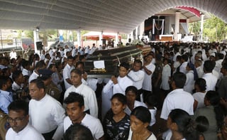 Familiares y amigos asisten al funeral de varias de las víctimas de los atentados en Colombo, Sri Lanka. El número de muertos en la serie de atentados se elevó a 321. (EFE)