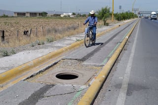 Se quejan de alcantarillas sin tapa en la ciclovía de la carretera a Matamoros, tanque representa un riesgo. (EL SIGLO DE TORREÓN/CLAUDIA LANDEROS) 