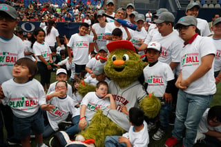 Orbit, la mascota de los Astros de Houston, posa con los participantes del evento Play Ball de las Grandes Ligas para niños de 5 a 13 años, durante la serie que se llevó a cabo en Monterrey. (AP)