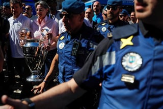 La vicealcaldesa de Madrid, Marta Higueras, con el trofeo de la UEFA Champions League en sus manos mientras avanza en la Puerta del Sol, custodiada por las autoridades de la capital española. (EFE)