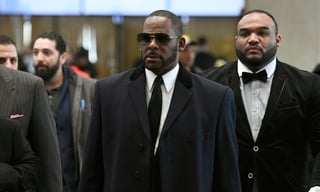 Acusado. El cantante R. Kelly, en el centro, llegando a un juzgado en Chicago para una audiencia. (AP)
