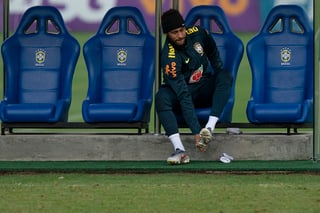 Neymar se calza los zapatos durante un entrenamiento de Brasil.