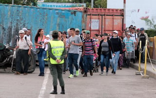 Largas colas de venezolanos se formaron en dos puentes internacionales cerca de Cúcuta para mostrar sus documentos de identidad a las autoridades colombianas. Guardias fronterizos venezolanos de uniformes verdes ayudaban a mantener el orden. (EFE)
