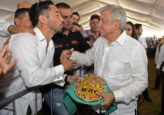 El presidente Andrés Manuel López Obrador (d), mientras recibe un cinturón del excampeón Fernando Montiel. (ARCHIVO)