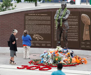 Aficionadas se detienen en la estatua de Pat Bowlen, durante el homenaje que se le hizo al exdueño de los Broncos. (AP)