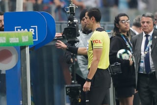 El árbitro Andrés Rojas observa el monitor del VAR durante un partido de la Copa América entre Uruguay y Japón. (AP)