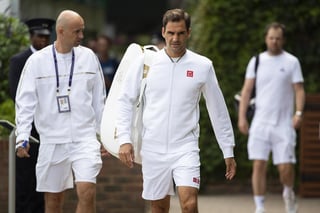 El tenista suizo Roger Federer (c) llega al entrenamiento de ayer en el All England Club de Wimbledon.