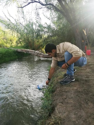En Cuclillas, Ricardo Magín Oyervides toma muestras de agua del arroyo en Cuatrociénegas. (EL SIGLO COAHUILA)