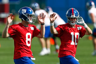 Los quarterbacks de Gigantes de Nueva York, Eli Manning (10) y Daniel Jones (8), calientan durante una práctica en Nueva Jersey.