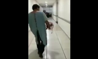 Un video que circula en redes sociales muestra al profesor con la bata del hospital, bolsa de suero y un ventilador portátil. (ESPECIAL)