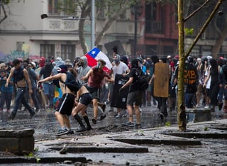 Manifestantes se enfrentan este lunes con Carabineros en los alrededores de la Plaza Italia, en Santiago de Chile. (EFE)