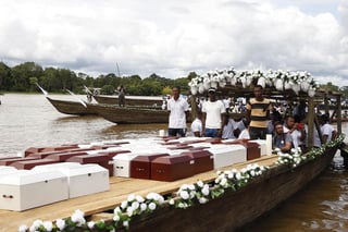 Familiares transportan por el río Atrato, en Colombia, los restos de las víctimas de la masacre ocurrida en 2002. (EFE)