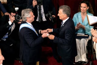 Fernández (i), recibe el bastón de mando de manos del presidente saliente, Mauricio Macri (d). (EFE) 