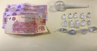 Se les encontraron 14 envoltorios pequeños con una sustancia semigranulada, la cual reúne las características de la droga conocida como cristal, además de 250 pesos y una pipa de cristal. (ESPECIAL)
