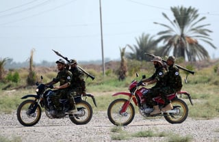 Miembros de las Fuerzas de Movilización Popular chií iraquí conducen motocicletas durante una sesión de entrenamiento en la base militar de Balad, al norte de Irak. (ARCHIVO, 2018)