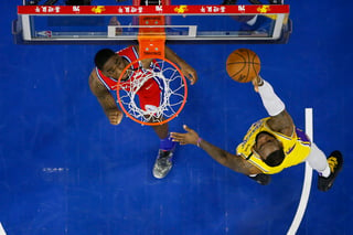 LeBron James (d) anota la canasta con la que rebasó a Kobe Bryant para ser el tercer máximo anotador en la historia de la NBA.