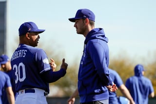 El mánager de Dodgers, Dave Roberts, habla con Cody Bellinger ayer, durante el entrenamiento primaveral. (AP)