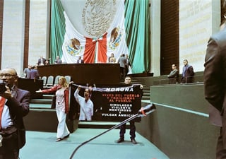Dos excolaboradores del legislador extendieron la pancarta hasta el frente del pleno, lugar en donde tiene su curul Fernández Noroña, lo que provocó empujones y gritos. (ESPECIAL)
