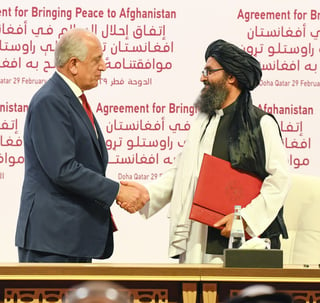 El representante para la Paz de EUA, Zalmay Khalilzad (i), y el mulá Abdul Ghani Baradar (d), se estrechan la mano. (EFE)