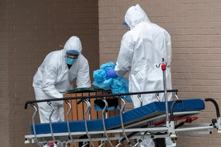 Personal médico de NY retira su equipo de protección tras retirar un cuerpo de una clínica. (AP) 
