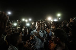 El fotógrafo japonés Yasuyoshi Chiba ha sido galardonado este jueves con el World Press Photo por su fotografía del grito pacífico de un grupo de jóvenes en Sudán, que iluminaban con sus teléfonos móviles a un chico mientras recitaba un poema a la multitud en medio de un apagón durante las protestas en Jartum el año pasado. (EFE)