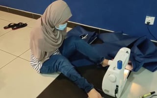 Un video difundido en la red muestra a la mujer cosiendo con ayuda de sus pies los cubrebocas (CAPTURA) 