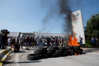 Trabajadores furiosos quemaron neumáticos en los portones de la fábrica automotriz Nissan en el noreste de España y se aprestaban a realizar otros actos de protesta cuando la empresa japonesa dijo que cerraría todas sus plantas en la región como parte de una reestructuración global. (ARCHIVO) 