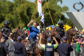 El presidente de Brasil, Jair Bolsonaro, saluda a simpatizantes el pasado domingo sobre un caballo, en Brasilia, la capital del país. (EFE) 