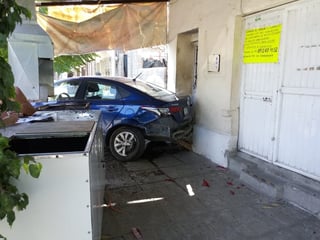 Arriba de la banqueta e impactado contra una finca terminó el automóvil Hyundai Accent tras el choque. (EL SIGLO DE TORREÓN)