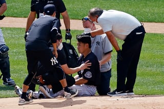 Masahiro Tanaka es atendido por los médicos de los Yanquis tras el golpe en la cabeza. (AP)