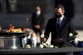 Los asistentes rodeaban un pebetero con una llama en memoria de los casi 30,000 fallecidos, que estuvieron presentes también en las rosas blancas que se depositaron junto a él. (EFE)