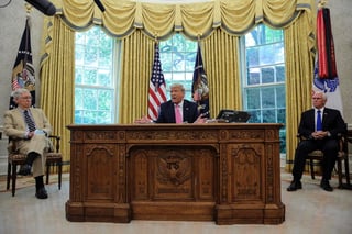 Sin un cubrebocas puesto, el presidente Donald Trump señala que es de patriotas usar cubrebocas. (EFE) 