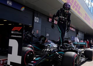 El piloto británico Lewis Hamilton desciende de su monoplaza tras obtener la 'pole' ayer.