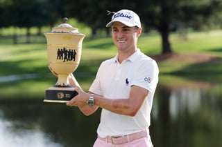 Justin Thomas sonríe con el trofeo de campeón.