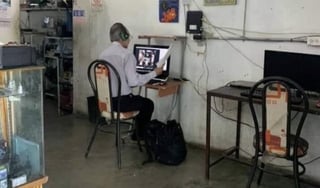 La instantánea que se viralizó en la red, muestra al hombre transmitir sus clases en línea desde un café internet (CAPTURA) 