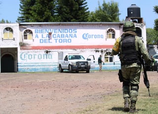 Integrantes federales de seguridad resguardan el sito donde al menos once personas fueron asesinadas en la madrugada, en el municipio de Jaral del Progreso, en Guanajuato.