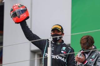El británico Lewis Hamilton sostiene un viejo casco de Michael Schumacher, que le obsequió el hijo del expiloto. (AP)