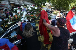 Miles de ciudadanos agolpados en las aceras, cantando, aplaudiendo, lanzando flores y portando banderas del FA saludaron el paso del vehículo con los restos mortales de Vázquez hacia el camposanto. (EFE)