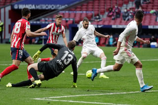 El francés Karim Benzema dispara para marcar el tanto del empate a un gol entre Real Madrid y el líder Atlético. (AP)