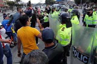 Manifestantes se encaran con policías en Bogotá ante las nuevas restricciones de movilidad en el país caribeño.
