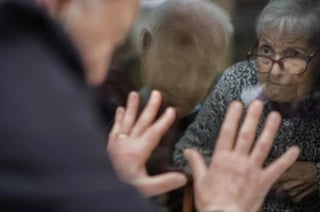 Antó, de 90 años, viene tres o cuatro veces por semana a la ventana a pie de calle que da al hogar de ancianos de Barcelona donde vive su esposa, de 92 años. (EFE)