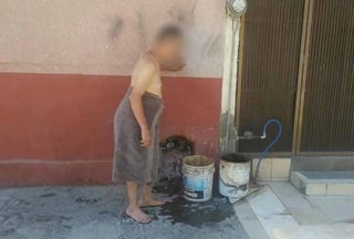 El vecino de la colonia Moderna, en Torreón, tuvo que salir en toalla para recolectar agua y continuar con su baño (REDES SOCIALES)  