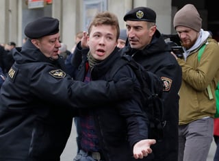Fotografía de 2017 de Protasevich (c) detenido por policías. (AP) 