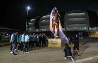 Jugadores de la selección argentina presencian la develación de una estatua de Diego Maradona frente al Estadio Madre de Ciudades, antes de su partido de la eliminatoria mundialista ante Chile en Santiago del Estero, el jueves 3 de junio de 2021 (Agustin Marcarian, Pool via AP)