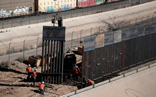 ARCHIVO - En esta fotografía del 22 de enero de 2019, unos trabajadores reemplazan unas vallas de metal en la frontera entre Texas y México, cerca de la localidad fronteriza de El Paso. (AP Foto/Eric Gay, Archivo)