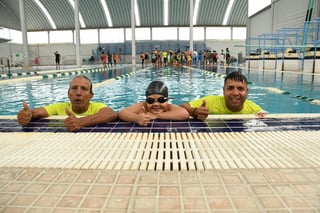 Alfredo Frayre Martínez (i), que lleva cuatro décadas y media como entrenador de natación y futbol, su hijo Óscar Frayre Álvarez y su nieto Mateo Frayre Ramírez, en la alberca de la UDT.