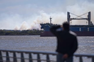 Un barco navega por el río Paraná; de fondo se observan las columnas de humo por los incendios. (ARCHIVO) 