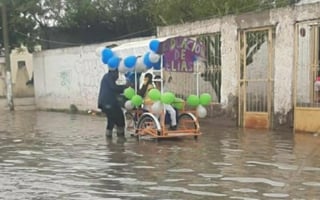 A través de redes sociales se viralizó la escena del padre festejando la graduación de su hijo en un triciclo en calles de Gómez Palacio, pese a las inundaciones registradas en algunas zonas de La Laguna (FACEBOOK)  